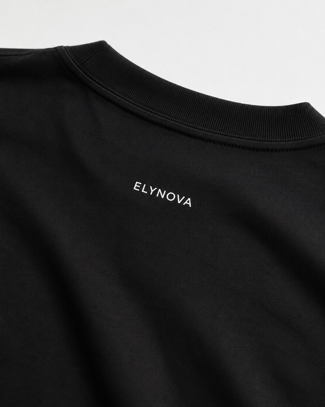 Oversized Tee in Black, close-up of ribbed collar and ELYNOVA logo