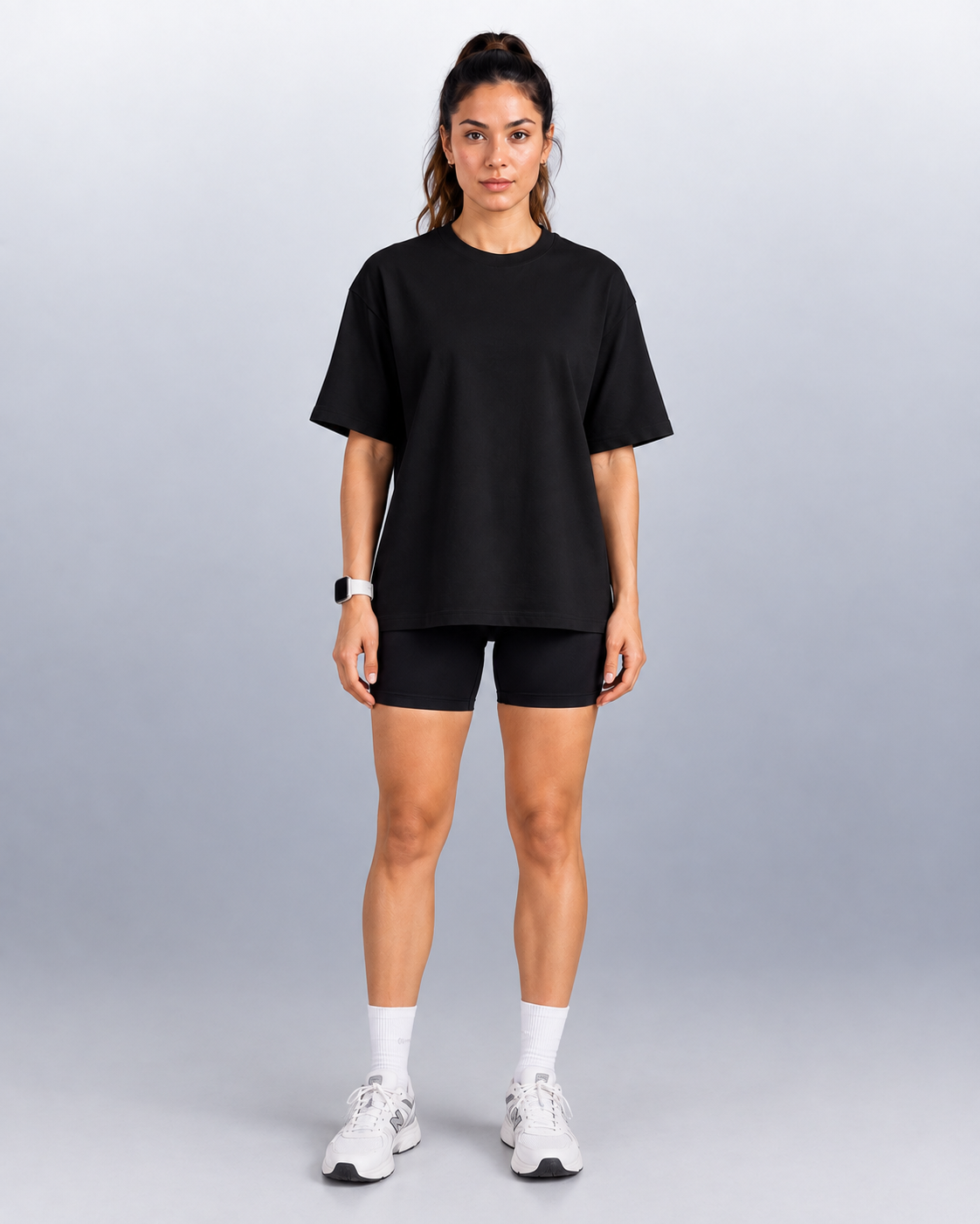 Oversized Tee in Black, full-body front view on a woman with bike shorts