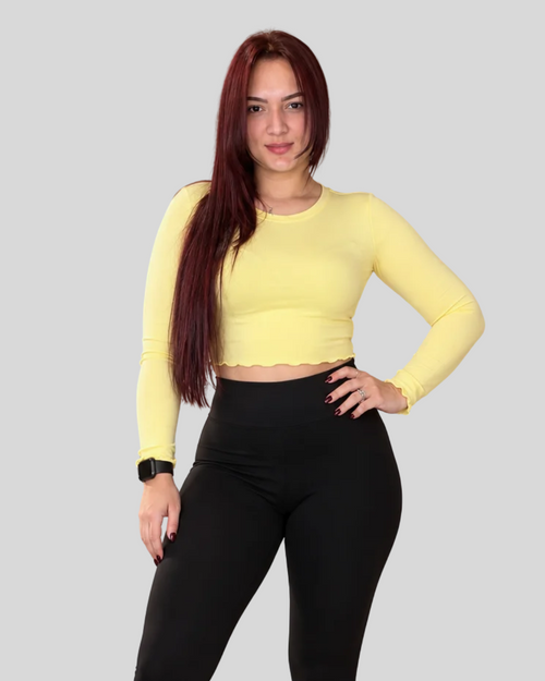 Aura Top in yellow, front view of long-sleeve crop top with black leggings